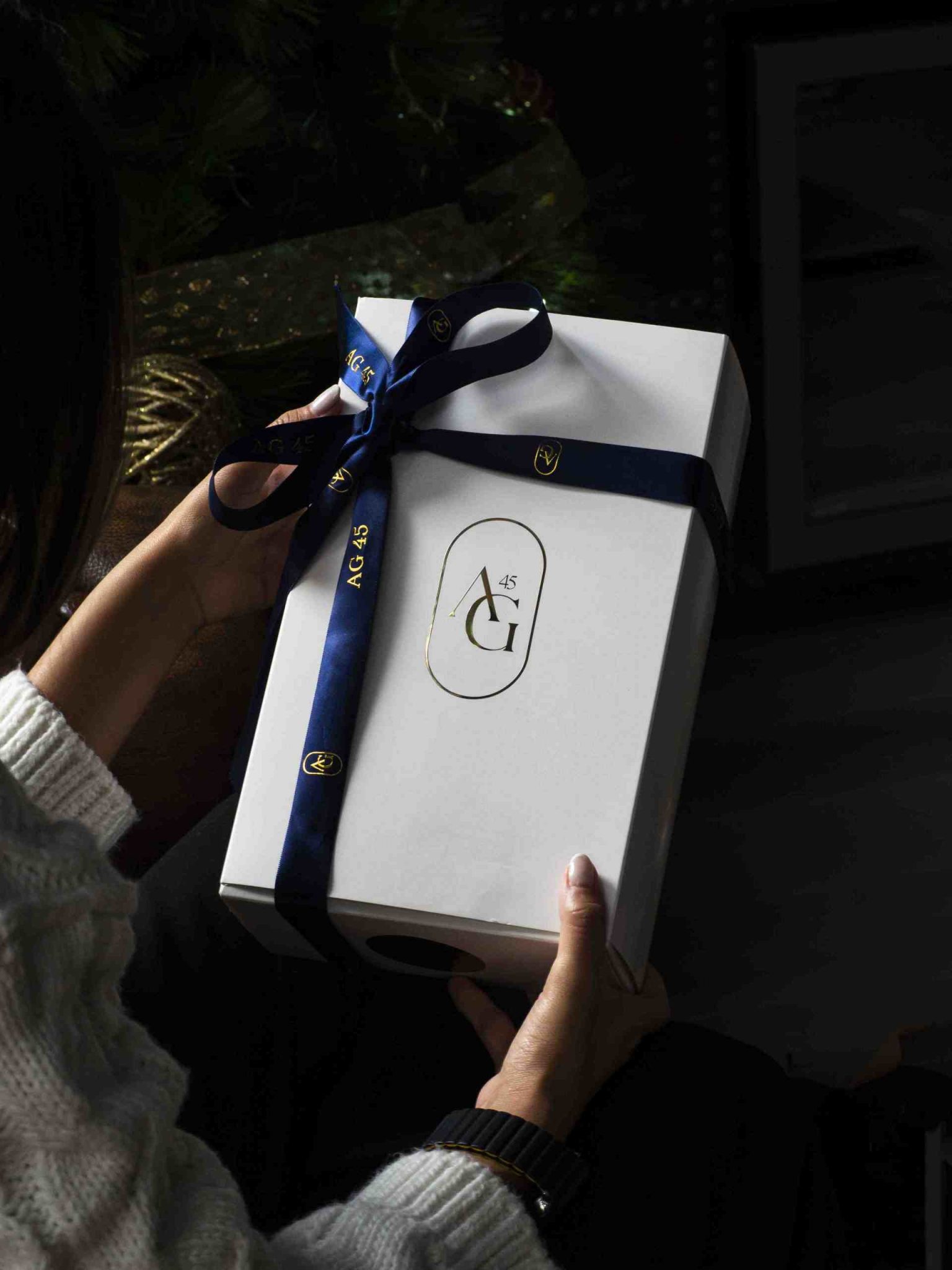 Caja blanca con cinta azul y logotipo AG45, pack aniversario diseñado como regalo exclusivo para clientes del programa de entrenamiento personalizado.