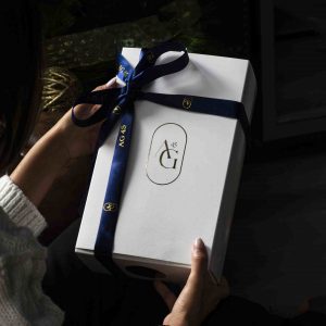 Caja blanca con cinta azul y logotipo AG45, pack aniversario diseñado como regalo exclusivo para clientes del programa de entrenamiento personalizado.