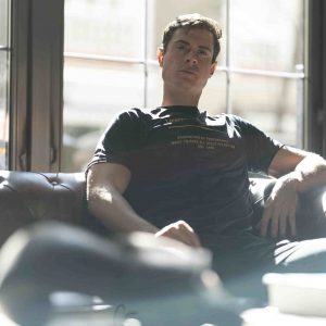 Entrenador personal en Madrid sentado en un sofá, reflejando confianza y profesionalismo en fitness personalizado. 3 mes online